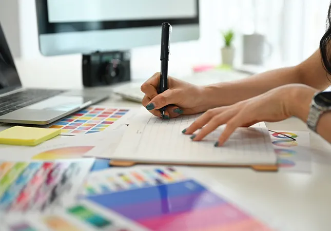 A person working with a graphics tablet next to colour swatches.