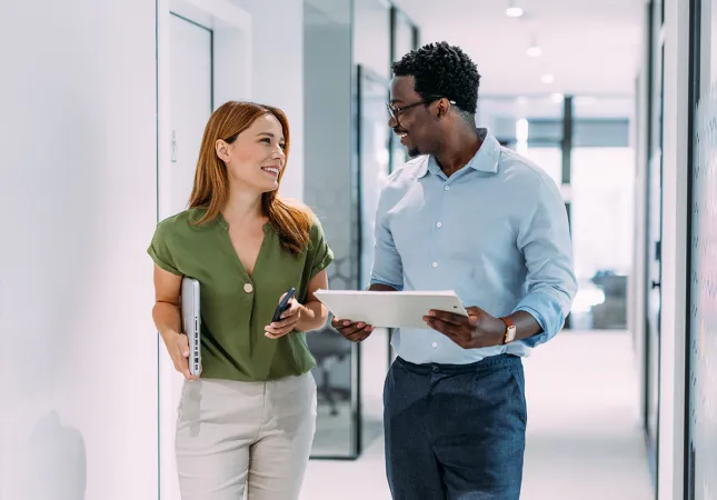 A man and a woman talking in a hallway.