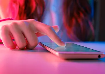 A person using a touchscreen mobile phone.