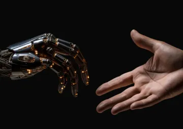 A robot hand and a human hand reaching out to each other.
